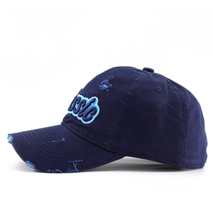 Close-up of distressed navy blue cotton baseball cap with embroidered Classic letters