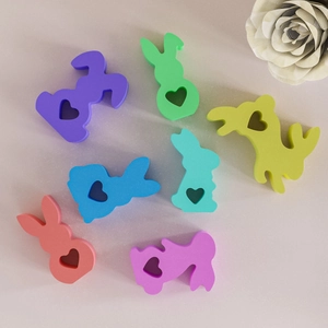 Vue détaillée de sept moules à lapin colorés en résine avec découpes en cœur