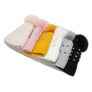 Set de 6 gorros de punto trenzado con grandes pompones de piel sintética y lunares.