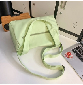 Détail du sac de yoga vert menthe montrant le tissu en nylon résistant et la poche latérale