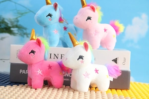 Vista dettagliata di quattro ciondoli unicorno di peluche colorati con corna dorate e stelle