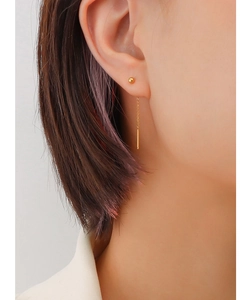 Close-up of 18K gold-plated long drop chain earrings with polished bar pendant