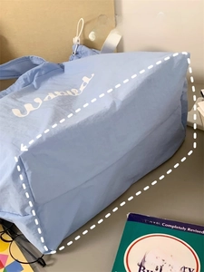 Detail view of the widened bottom design on light blue tote bag for extra storage space
