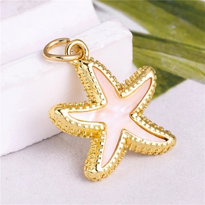 Detailed close-up of golden starfish pendant with pink enamel and zircons for DIY jewelry