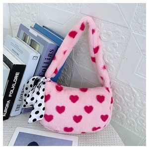 Detail of pink faux fur shoulder bag featuring red hearts and a polka dot silk ribbon