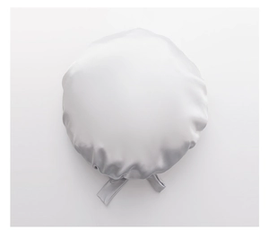 Detail of silver silk satin sleep cap with adjustable ribbons on white background