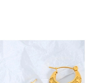 Detail of gold geometric hoop earrings with textured beaded finish on white background
