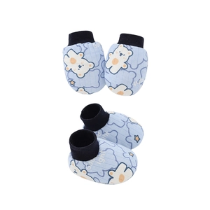 Dettaglio di scarpine blu per neonati con simpatico orso bianco e stelle stampate