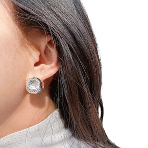 Silver textured firework stud earrings shown on model with minimalist radial design