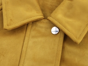Detail der gelben Bomberjacke aus Wildlederimitat mit Silberknopf und doppelter Steppnaht