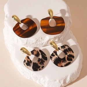 Boucles d'oreilles géométriques rétro en résine léopard sur présentoir en pierre