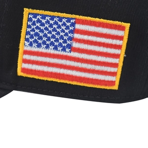 Détail macro de la broderie 3D drapeau américain sur une casquette en coton noir de qualité