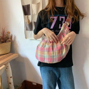 Detail of colorful plaid canvas hobo bag showing vibrant pink yellow and green patterns