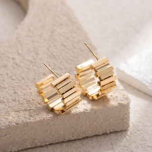 Golden chunky tiered C-shaped hoop earrings with a textured geometric design