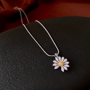 Close-up of zircon daisy pendant featuring white petals and yellow crystal core on silver chain