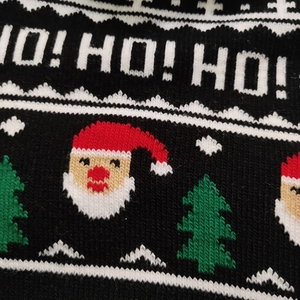 Macro view of Christmas knit beanie fabric with woven white HO! HO! HO! text