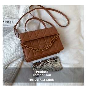 Gros plan d'un sac matelassé marron avec chaîne épaisse et téléphone pour l'échelle