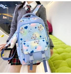 Detail of light blue student backpack with cartoon bear patterns and cute rabbit pendant