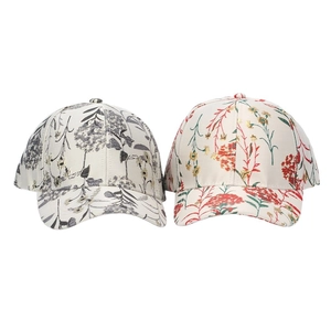 Detail view of two ethnic print baseball caps with floral patterns on cotton canvas fabric