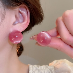 Detail view of pink round cat eye stone stud earrings with high gloss finish
