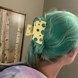Detail of creative yellow cheese shaped hair claw clip worn on a ponytail for women