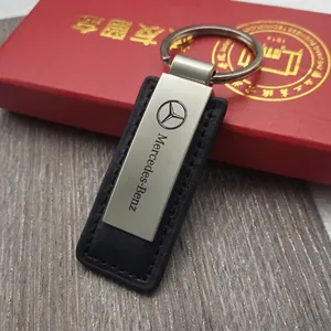 Premium silver brushed metal and black leather Mercedes-Benz keychain on wooden desk