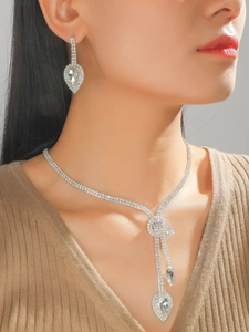 Detailed view of silver bridal jewelry set with water drop pendants and bow design