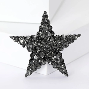 Elegant red star brooch with sparkling dark gray crystals on a minimalist white background