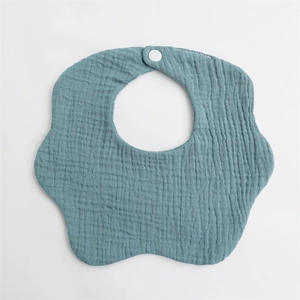 Detail showing the snap fastener and ripple texture of the blue cotton baby bib