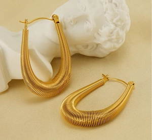 Detailed macro view of U-shaped gold earrings with unique horizontal coil texture
