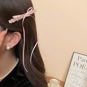 Detail of pink bow hair clip with crystals and pearls worn for an elegant look