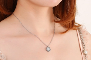 Close-up of a silver titanium steel necklace with a Roman numeral crystal pendant