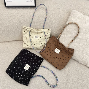 Detail of corduroy bags with heart bow patterns and colorful beaded shoulder straps