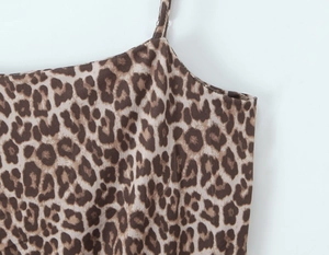 Close-up of leopard print fabric texture and thin shoulder strap of the jumpsuit
