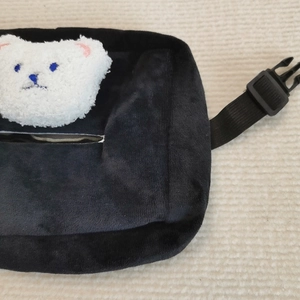 Detail of black velvet car tissue holder featuring a cute plush bear and adjustable strap