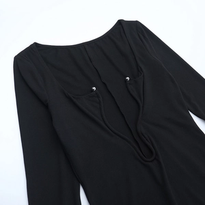 Gros plan du décolleté d'une robe noire avec des boules décoratives en métal argenté
