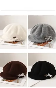 Detail showing wool newsboy caps in four colors with bowknot and leather patch