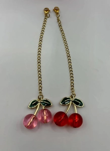 Detail of pink and red cherry pendants with gold chains for Stanley cups and bags