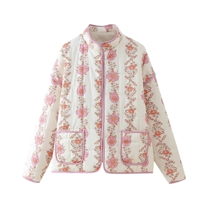 Detail of vintage floral quilted jacket with pink trim and delicate vertical stitching