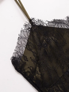 Gros plan détaillé d'une robe en satin vert olive avec dentelle de cils noire raffinée
