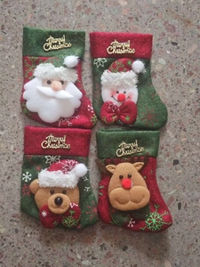 Detail of red and green felt Christmas stockings with Santa, Snowman and Reindeer patterns