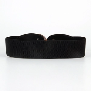 Detail of wide black elastic waist belt with high stretch fabric and gold metal buckle