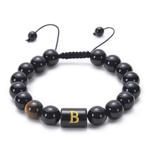 Detail of adjustable black onyx bead bracelet with tiger eye stone and golden letter B