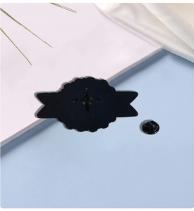 Detail view of the black metal pin back with three pins and butterfly clutches