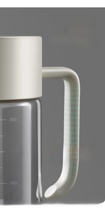 Détail de la poignée ergonomique et de la bouteille d'huile en verre avec échelle
