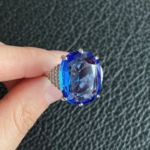 Anello di fidanzamento con zaffiro blu ovale in argento e pavé di diamanti sui lati