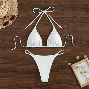 White ribbed halter bikini set with tie strings shown on a rustic wooden surface
