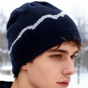 Winter navy blue knit beanie with white zigzag pattern worn in snowy outdoor setting