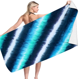 Detailed texture of microfiber beach towel with blue and green tie-dye gradient patterns
