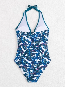 Detail of tropical leaf print one-piece swimsuit with halter neck and bow tie design